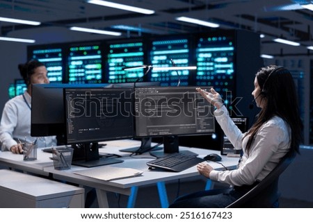 Data center workers in remote call, providing customer support, troubleshooting damages. Coworkers in server hub carrying out operational interventions requested by clients, using microphone