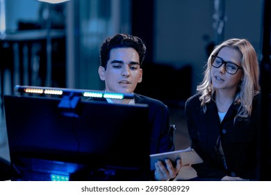 Data deep dive session. Lead analyst points to key metrics on screen comparing dashboard visualization with printed financial report validating findings with team members late night.