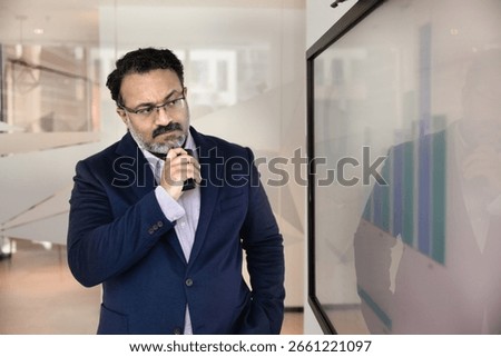 Data driven analysis. Thoughtful mature businessman corporate ceo financial analyst project leader look at screen with statistic graphs in boardroom contemplate market forecast ponder investment risks