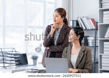 Data Driven Decisions: A team of professionals analyze data on a laptop, collaborating on strategy and insights. They point at charts and graphs, demonstrating their expertise and focus on results.	