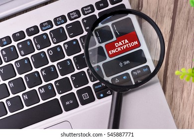DATA ENCRYPTION word written on keyboard view with magnifier glass