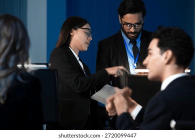 Data integrity check night shift Diverse team meticulously audits financial performance comparing figures tablet screen printed reports ensuring accuracy crucial validation process underway hub.