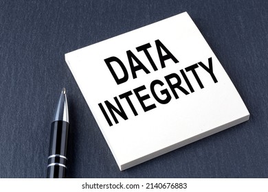 DATA INTEGRITY text on sticker with pen on the black background