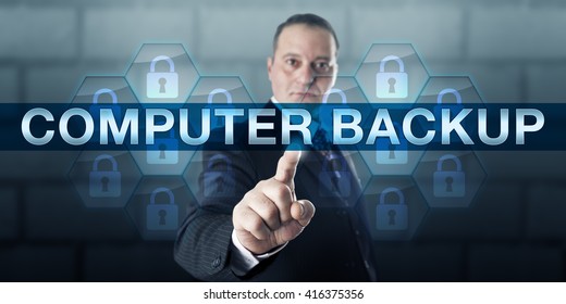 Data manager pushing COMPUTER BACKUP on a virtual touch screen interface. Information technology concept for the practice of copying and archiving computer files to prevent data loss or corruption.