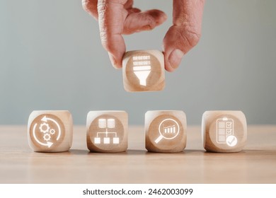 Data mining concept, Hand holding wooden block on desk with data sets, pre processing, database, analytics and evaluation icon on virtual screen.