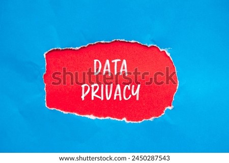Data privacy words written on ripped blue paper with red background. Conceptual data privacy symbol. Copy space.