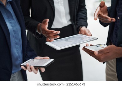 Data processing minus the paper. Shot of a group of businesspeople using wireless devices during a meeting in a modern office. - Powered by Shutterstock