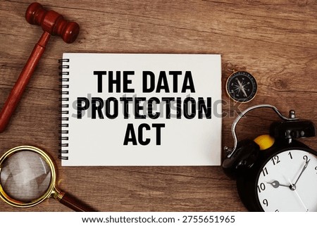 The Data Protection Act message written on notepad with alarm clock, wood gavel and magnifying glass flat lay on wooden background
