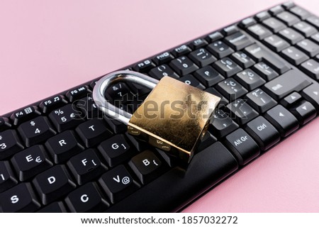 Data protection minimal concept. Flat lay setup on pink backdrop. Lock and keyboard.