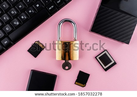 Data protection minimal concept. Flat lay setup on pink backdrop. Lock and keyboard.