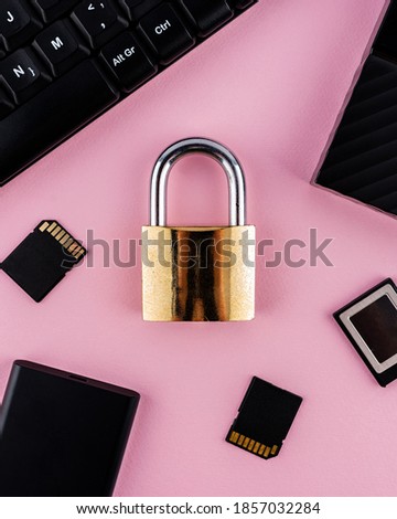 Data protection minimal concept. Flat lay setup on pink backdrop. Lock and keyboard.