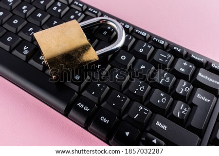 Data protection minimal concept. Flat lay setup on pink backdrop. Lock and keyboard.