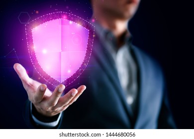 Data protection and network security concept. Glowing light Shield on business man hand for internet fire wall protect, insurance, or computer virus cleaner.