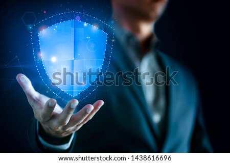 Data protection and network security concept. Glowing light Shield on business man hand for internet fire wall protect, insurance, or computer virus cleaner.