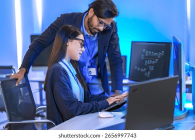 A data science team collaborates, analyzing a neural network model and code on multiple screens. Concept for AI development, machine learning, and data analysis.