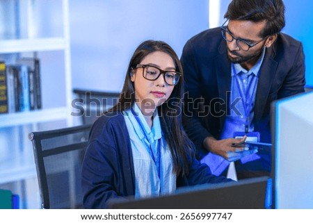 A data science team collaborates, analyzing a neural network model and code on multiple screens. Concept for AI development, machine learning, and data analysis.