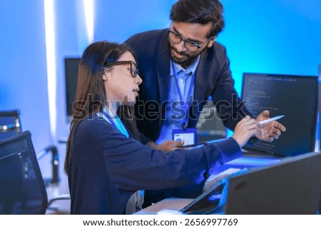 A data science team collaborates, analyzing a neural network model and code on multiple screens. Concept for AI development, machine learning, and data analysis.