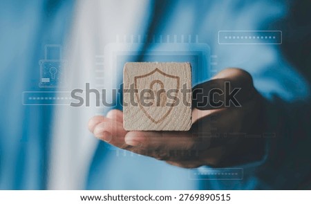 data security, privacy protection, cybersecurity awareness, safe information storage, risk management in digital business environment. Hand holding wooden block with engraved lock shield symbol