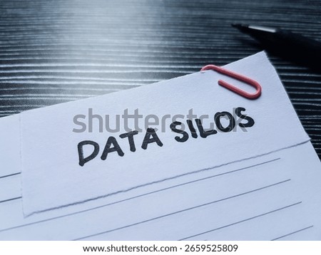 Data silos writting on table background.