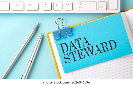 DATA STEWARD Text On Sticker On Blue Background With Pen And Keyboard