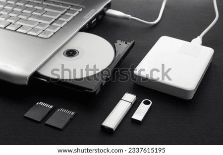 data storage devices connected to a laptop, data security, digital data storage, laptop open optical drive with disk