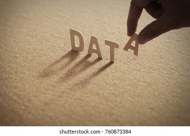 DATA wood word on compressed or corkboard with human's finger at A letter.
