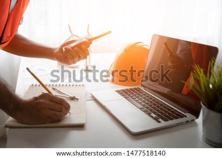 data working and tablet, laptop with architectural project at construction site at desk in office