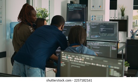Database admins collaborating on group project compiling algorithm for new cloud computing user interface on computer. Multiethnic team of software engineers developing html script code.