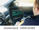 Database, laptop and a police officer in a car for security, urban law and safety data while working. Screen, programming and male protection professional with a computer to hack system in transport