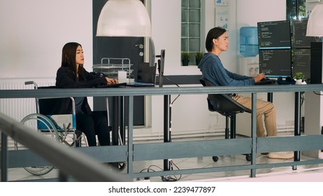 Database programer with physical disability writing code on computer screen, coding artificial intelligence algorithm. Engineer with impairment programming database on terminal window.