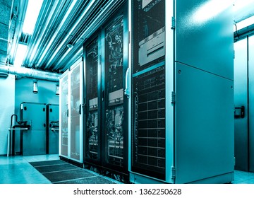 Datacenter server racks with network computers in neon blue toning. Room with several of mainframe hardware and supercomputers in big modern data center