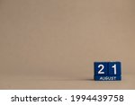 Date 21 August on blue dice on a beige eco-background