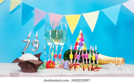 Date of birth with candles and number  79. Anniversary greeting card. Holiday decorations. Happy birthday candles. Multicolored decorations with garland