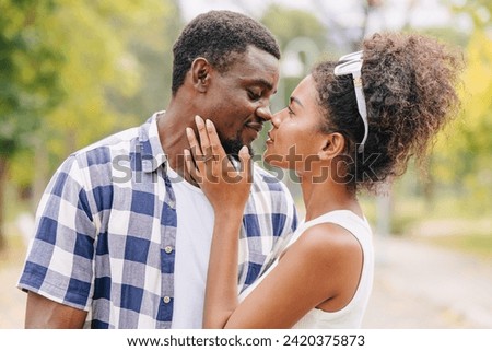 Date couple man and women kiss valentine day. African black lover kissing at park outdoors summer season vintage color tone