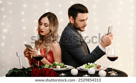 Date Fail. Bored Couple Using Smartphones Sitting Back To Back On Romantic Dinner In Restaurant, Ignoring Each Other.