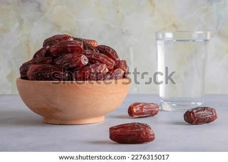 Date fruits with water on bright background