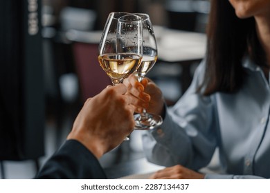 A date in a hotel restaurant man and a woman drink white wine in glasses close-up - Powered by Shutterstock