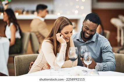 Date, laughing and interracial couple with wine in fine dining, luxury restaurant or valentines celebration together. Funny black man, happy woman and alcohol glasses for romance, rich or anniversary - Powered by Shutterstock