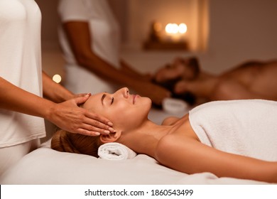 Date In Spa. Couple Enjoying Head Massage Together Relaxing Lying On Beds With Eyes Closed In Beauty Salon Indoor, While Masseuse Massaging Body. Beauty, Wellness And Relaxation Selective Focus