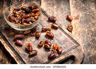 Dates in a bowl. On wooden background.