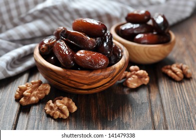 Dates fruit in a wooden bowl closeup on wooden background