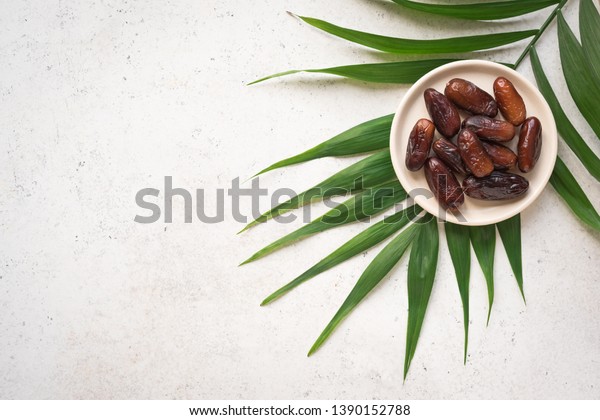Dates fruits on plate on white\
background, top view, copy space. Organic dried dates\
fruits.