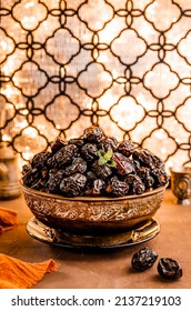Dates fuits (Kurma Ajwa) in brown plates with golden table and background. 