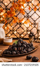 Dates fuits (Kurma Ajwa) in brown plates with golden table and background. 