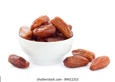 Dates in a white bowl on a white background.