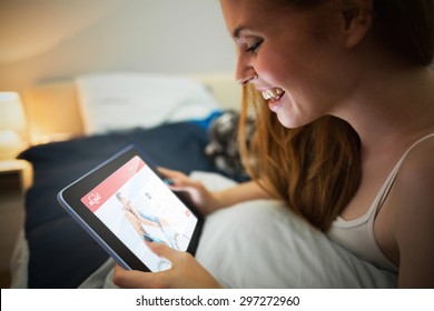 Dating website against pretty redhead using tablet lying on her bed