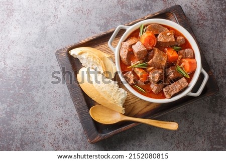 Daube de Boeuf Provencale slow cooked Rich Beef Stew closeup in the wooden tray on the table. Horizontal top view from above
