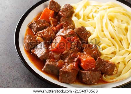 Daube de Boeuf Provencale slow cooked Rich Beef Stew with noodles closeup in the plate on the table. Horizontal

