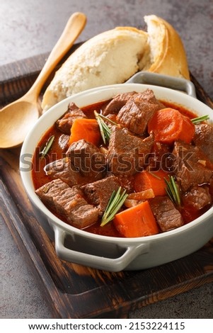 Daube Provencal French braised beef red wine, and vegetable stew closeup in the wooden tray on the table. Vertical
