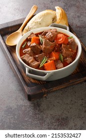 Daube Provencal French stew beef with vegetables is slow simmered to tenderness closeup in the wooden tray on the table. Vertical
